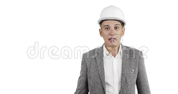 一个穿着白色建筑头盔和西装的有魅力的男人看着相机说话视频的预览图