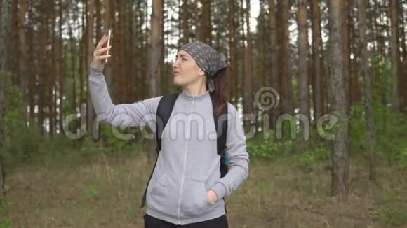 在森林里试图捕捉移动信号的年轻女子视频的预览图