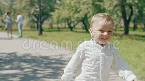 从父母身边跑出来的小男孩慢动作的幸福家庭视频的预览图