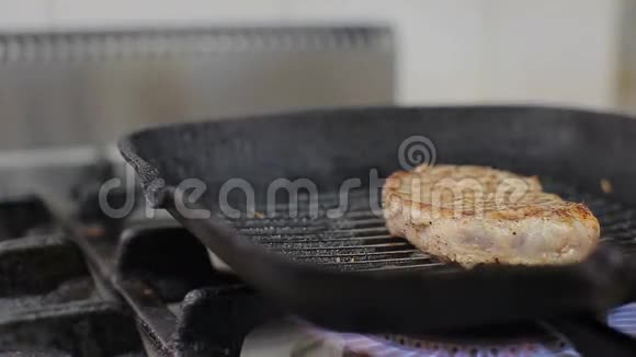 厨师正在烤架上烤牛排厨师烤肉肉上的迷迭香和大蒜把牛排翻过来视频的预览图