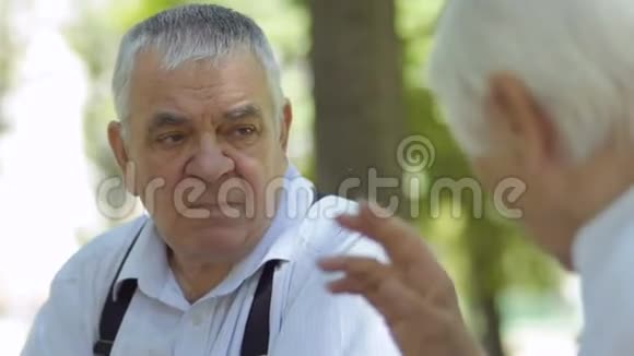 在公园里聋哑老人和聋哑妻子用手交谈视频的预览图