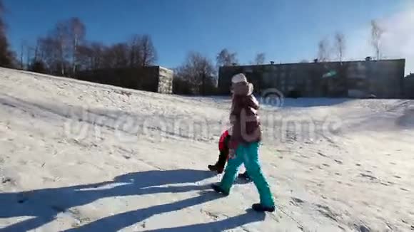 带着雪橇上山的女孩视频的预览图