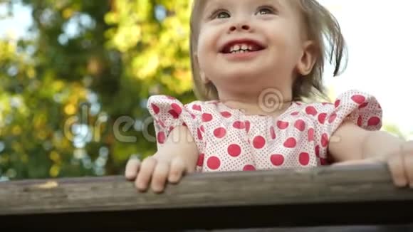 小快乐的宝宝微笑着第一颗牙齿在公园的博克背景下玩耍视频的预览图