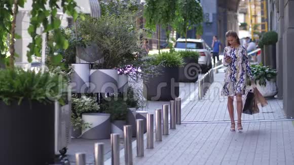 日落后一个女人带着购物袋在城市里散步视频的预览图