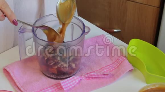 自制糖果放在盘子里旁边的食材为他们准备女人把蜂蜜加到搅拌机里视频的预览图