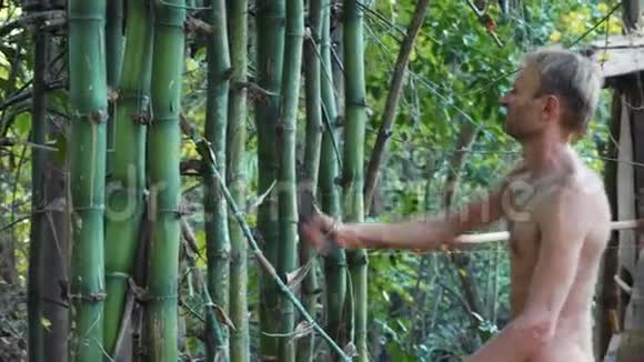白种人在森林里用砍刀砍竹视频的预览图