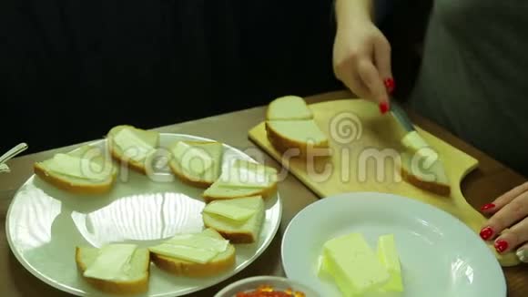 一个女人用鱼子酱在面包上切黄油做罐头视频的预览图