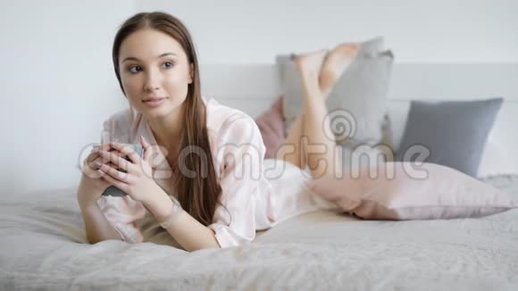 迷人的女人在空闲时间独自躺在床上视频的预览图