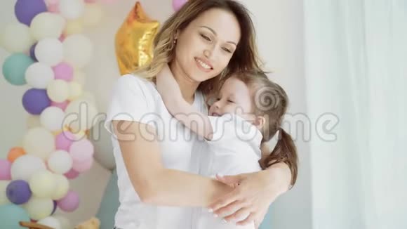 小女孩和妈妈拥抱一个女人吻她的小女儿视频的预览图