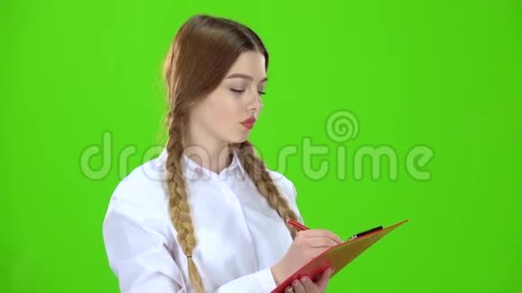 女孩在白色的平板电脑上写字绿色屏幕视频的预览图