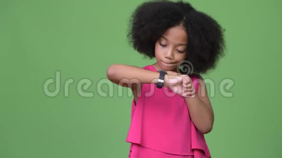 年轻可爱的非洲女孩留着非洲的头发看时间视频的预览图