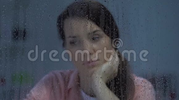 忧郁的中年女士望着雨窗忍受着孤独视频的预览图