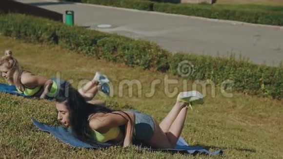 在户外做俯卧撑户外瑜伽垫锻炼的漂亮苗条女性视频的预览图