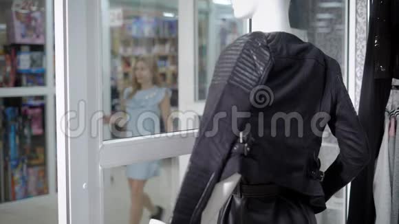 一位年轻的女士穿着一件时髦的连衣裙穿着一件皮背心她想在精品店里买一件视频的预览图