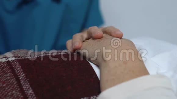 义工手握躺床上的老年女性病人照顾及支援视频的预览图