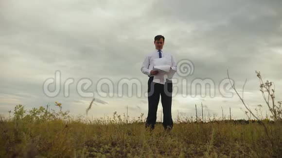穿着白色衬衫和领带的商人正在玩纸飞机在乌云的背景下微笑视频的预览图