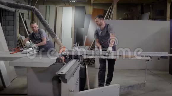两名木匠正在工厂的一家联营商店工作他们正在切割刨花板准备生产家具视频的预览图