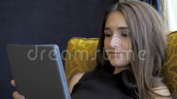 美丽的女孩躺在酒店的沙发上视频的预览图