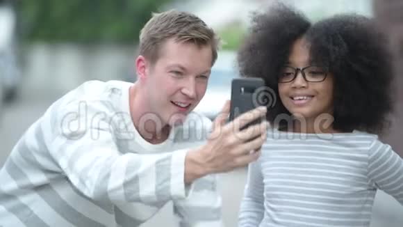 年轻可爱的非洲女孩非洲头发年轻的斯堪的纳维亚人一起在户外的街道上视频的预览图