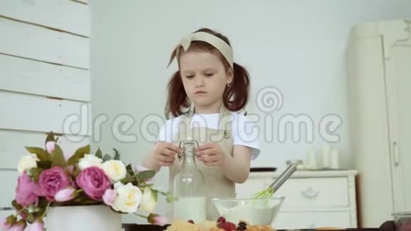 一个小女孩把牛奶从瓶子里倒入一个有面粉的盘子里做煎饼视频的预览图