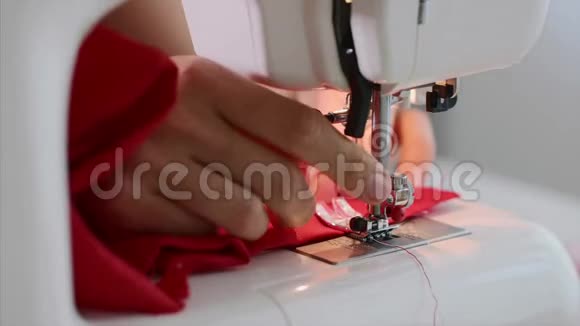 女裁缝手用直缝机缝制红色服装视频的预览图