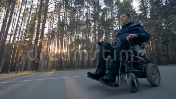 残障人士乘坐电动轮椅沿着道路行进视频的预览图