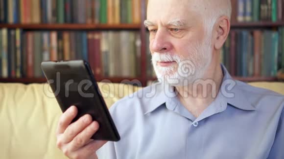 年长的老人在家放松阅读享受退休生活的电子书背景书架视频的预览图