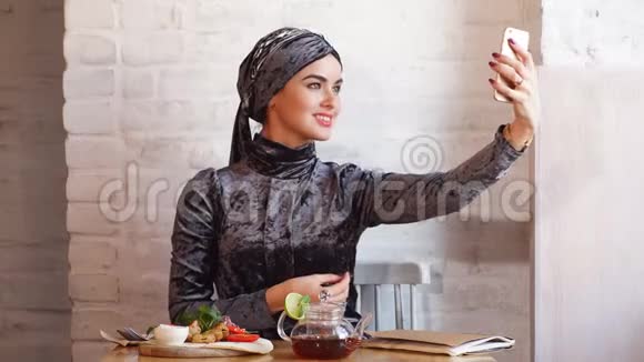 年轻漂亮的穆斯林女孩在咖啡馆自拍视频的预览图