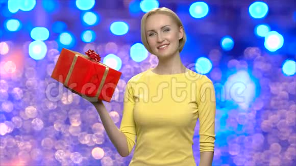 漂亮的女人拿着红色的圣诞礼物盒视频的预览图