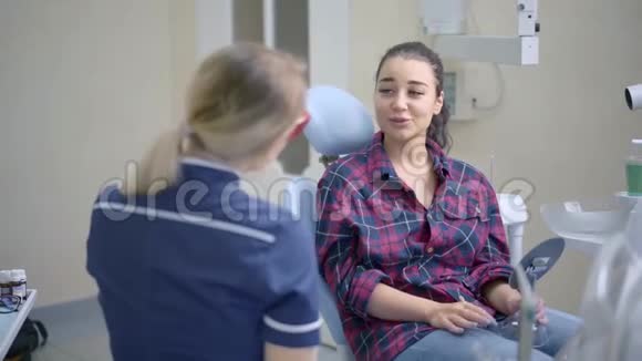 女牙医与牙科诊所的病人交谈视频的预览图