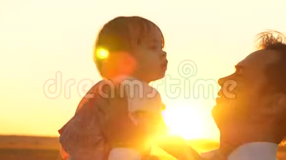 婴儿在教皇手中微笑日落快乐的爸爸在夕阳下和宝宝玩视频的预览图