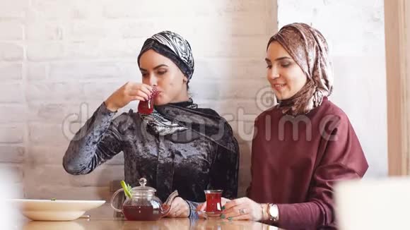 两个女人坐在椅子上享受食物时说话的肖像视频的预览图