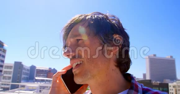 男摄影师在露台4k用手机聊天视频的预览图