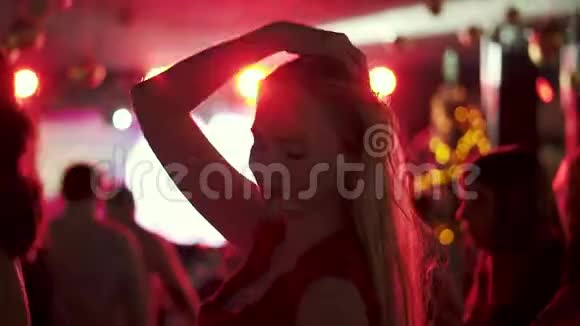 一位年轻女子在人群中的聚会上跳舞的肖像视频的预览图