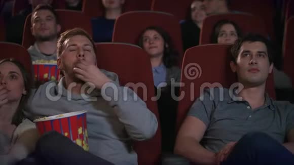 可爱的一对拥抱在电影院里电影院朋友们欣赏电影视频的预览图