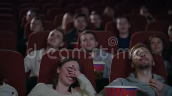 年轻人在电影院笑看有趣喜剧的年轻人视频的预览图