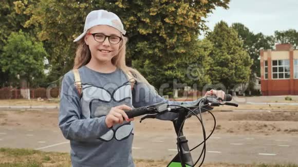 夏天金发小女孩在城里骑着自行车摆姿势视频的预览图