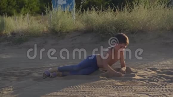 快乐的孩子躺在草原的尘土和沙子里享受自由游戏视频的预览图