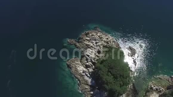 热带雨林覆盖的小岛上的空中森林周围的石岸带漂亮的水晶海水视频的预览图