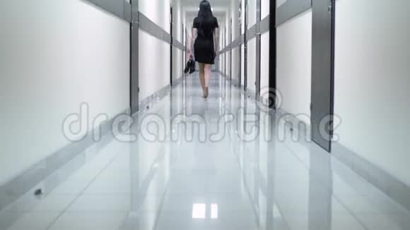 后景一个穿着黑色礼服的女人走在酒店的走廊上她手里拿着鞋子视频的预览图