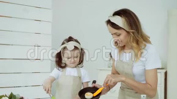 一个小女孩和她妈妈一起准备奶酪蛋糕视频的预览图