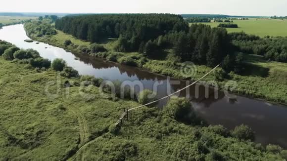 飞过村庄田野河流和森林美丽鸟瞰挂在河上的老桥视频的预览图