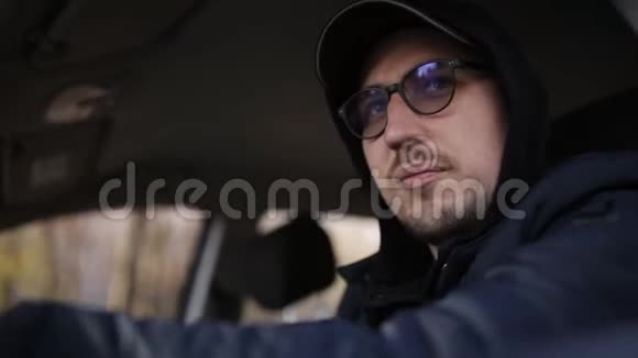 年轻的私家侦探坐在车里用单反相机拍照视频的预览图