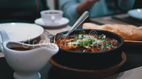 餐厅Ketsi的格鲁吉亚肉盘查舒舒利餐桌上的泥锅热肉视频的预览图