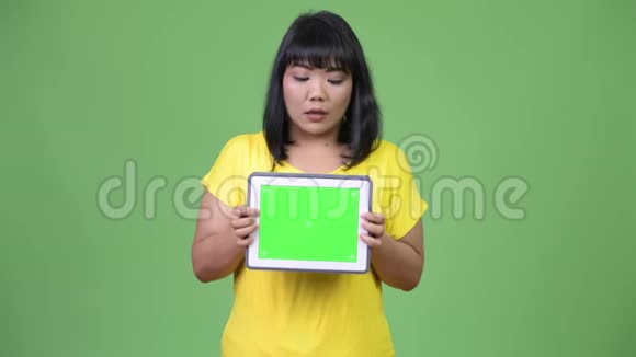 美丽的亚洲女人展示数码平板电脑神情震惊视频的预览图