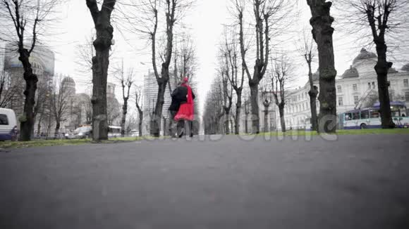 年轻夫妇在寒冷空旷的冬街上跳探戈周围是赤裸的树木视频的预览图