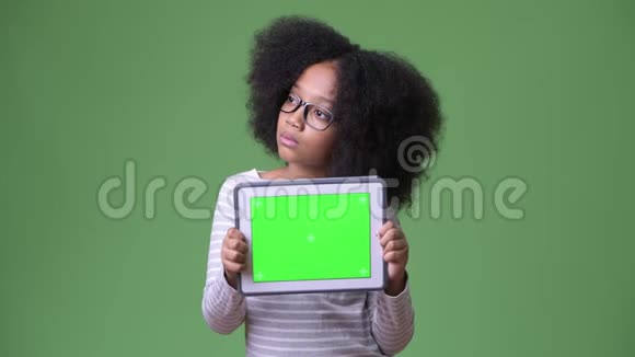 年轻可爱的非洲女孩带着非洲头发一边看数码平板电脑一边拍照视频的预览图