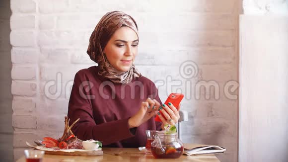 年轻的穆斯林妇女拿着智能手机打电话发短信视频的预览图