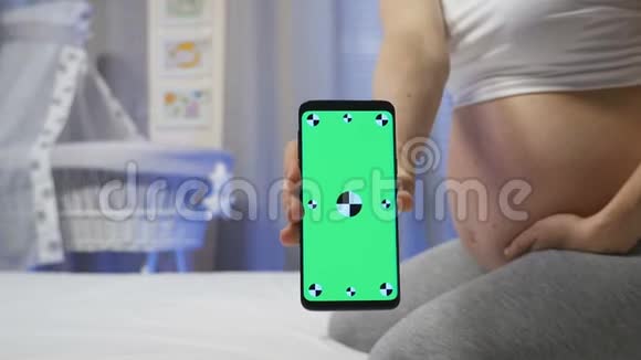 孕妇手持绿屏手机视频的预览图