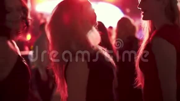 在夜总会迪斯科舞厅里朋友们在红色聚光灯下跳舞女孩在人群中跳舞视频的预览图